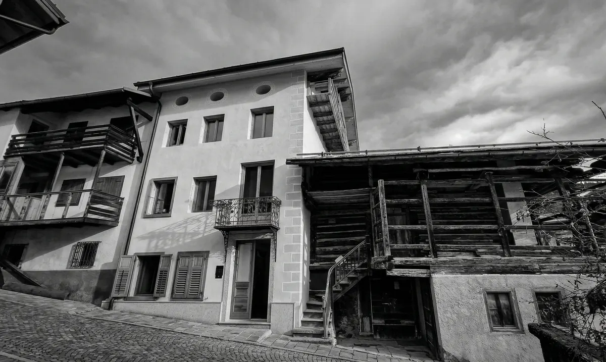Ristrutturazione di casa storica nelle Dolomiti con serramenti e persiane in larice naturale, architettura alpina tradizionale